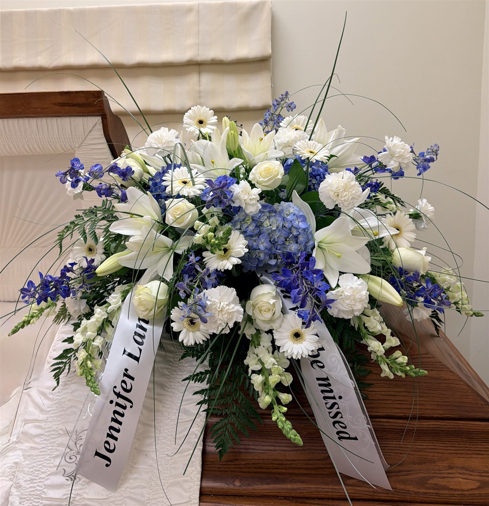 Half couch casket spray in blue and white at a Clark County funeral service
