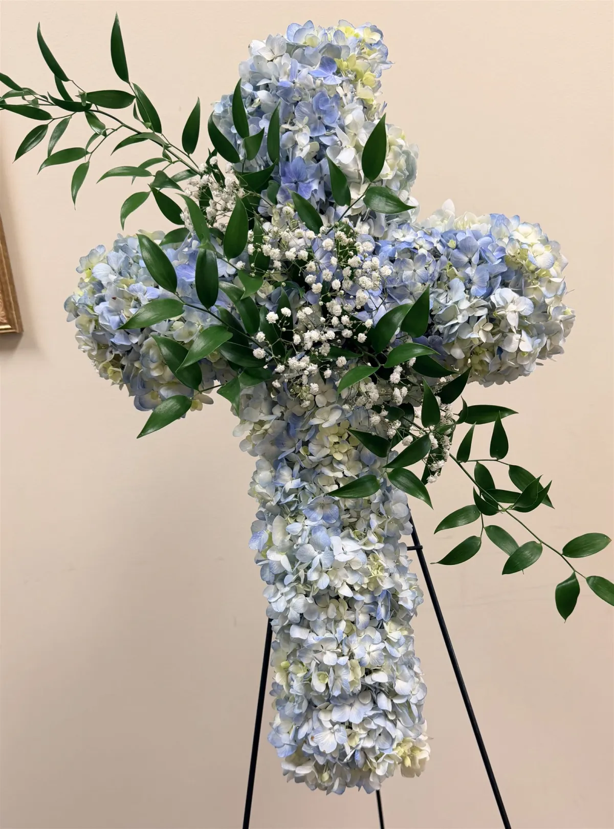 Blue hydrangea flower cross on an easel